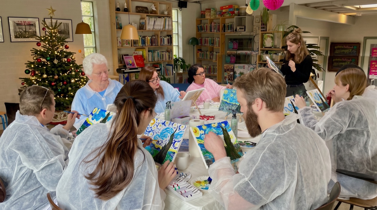 Groep schildert De Sterrennacht tijdens een workshop